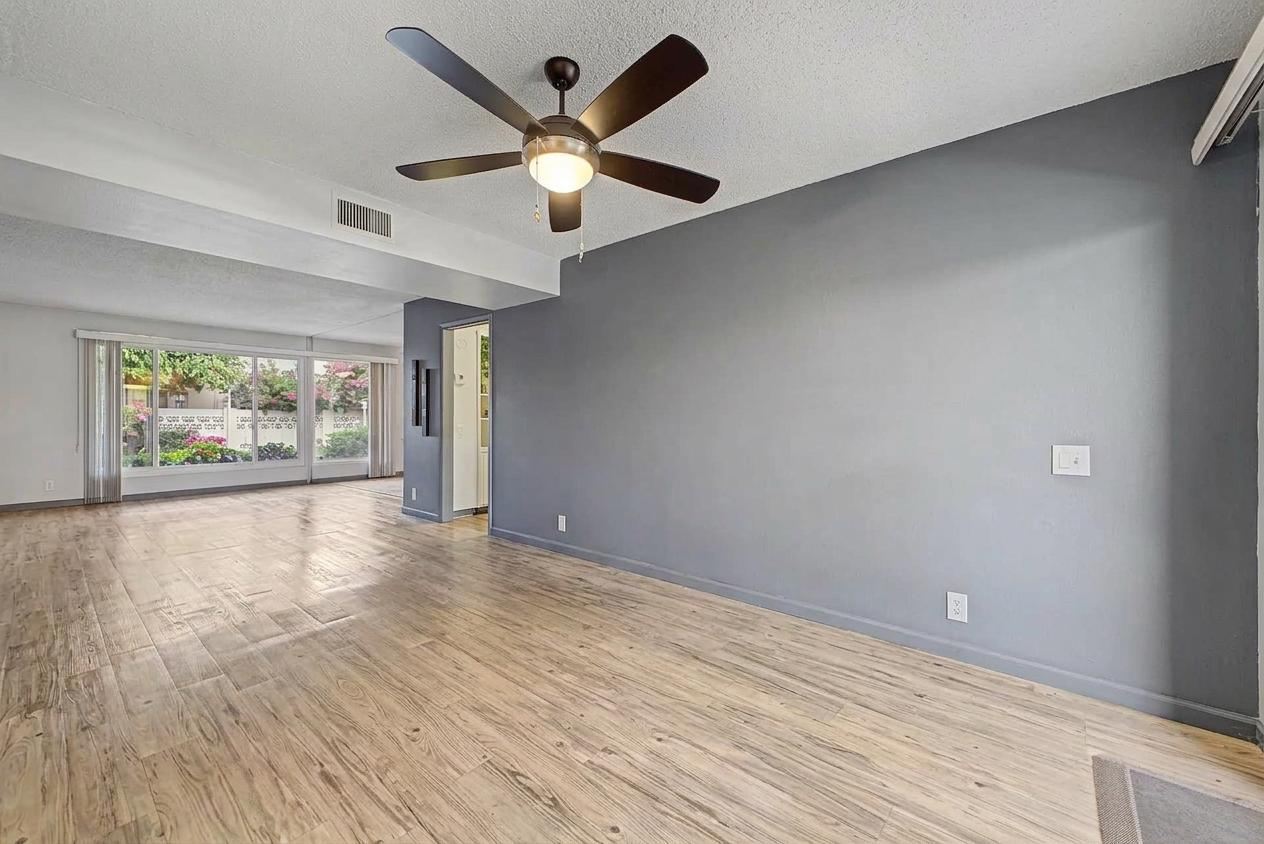 Living area with charcoal accent wall and garden-facing windows