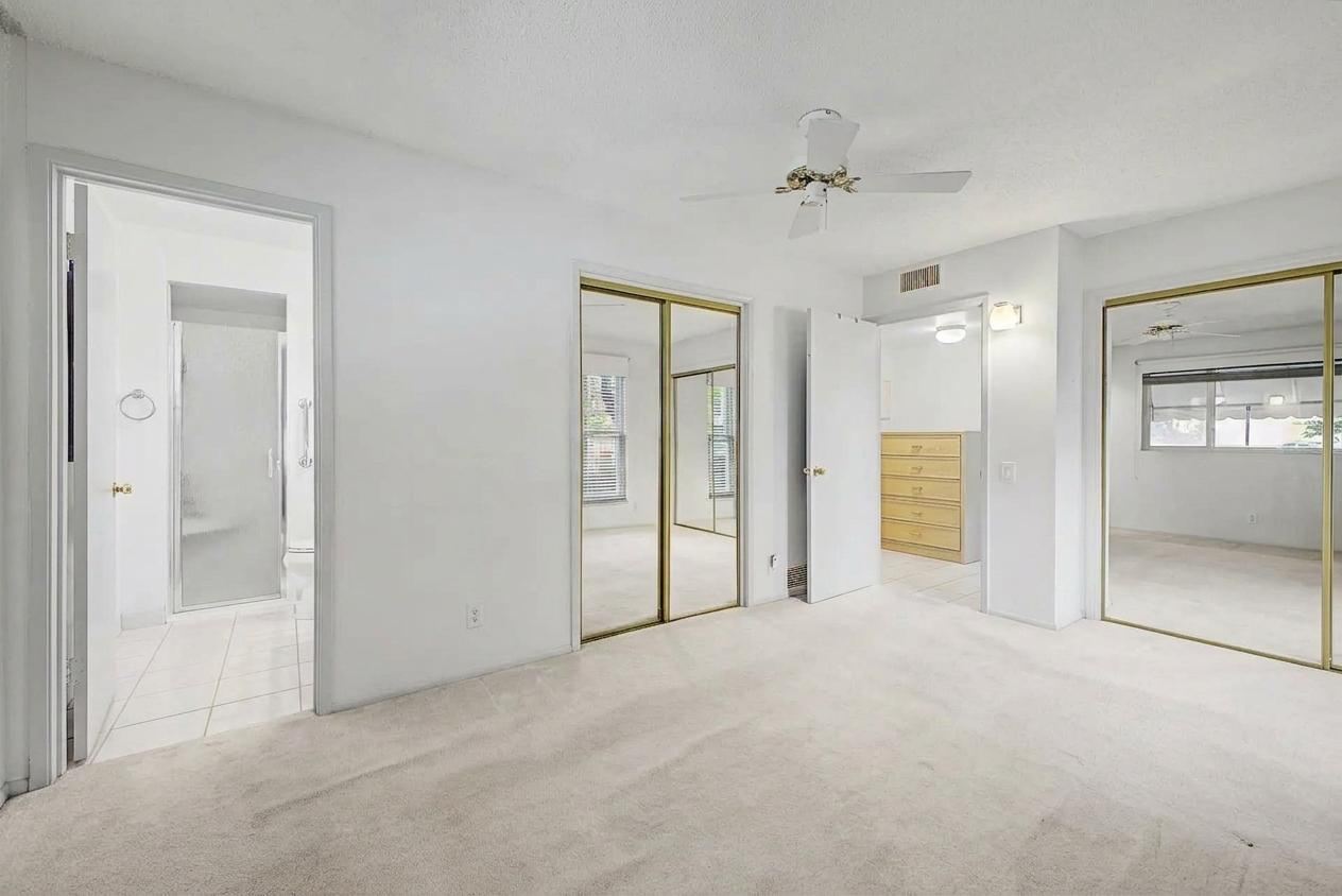 Primary bedroom with double mirrored closets and adjoining bathroom