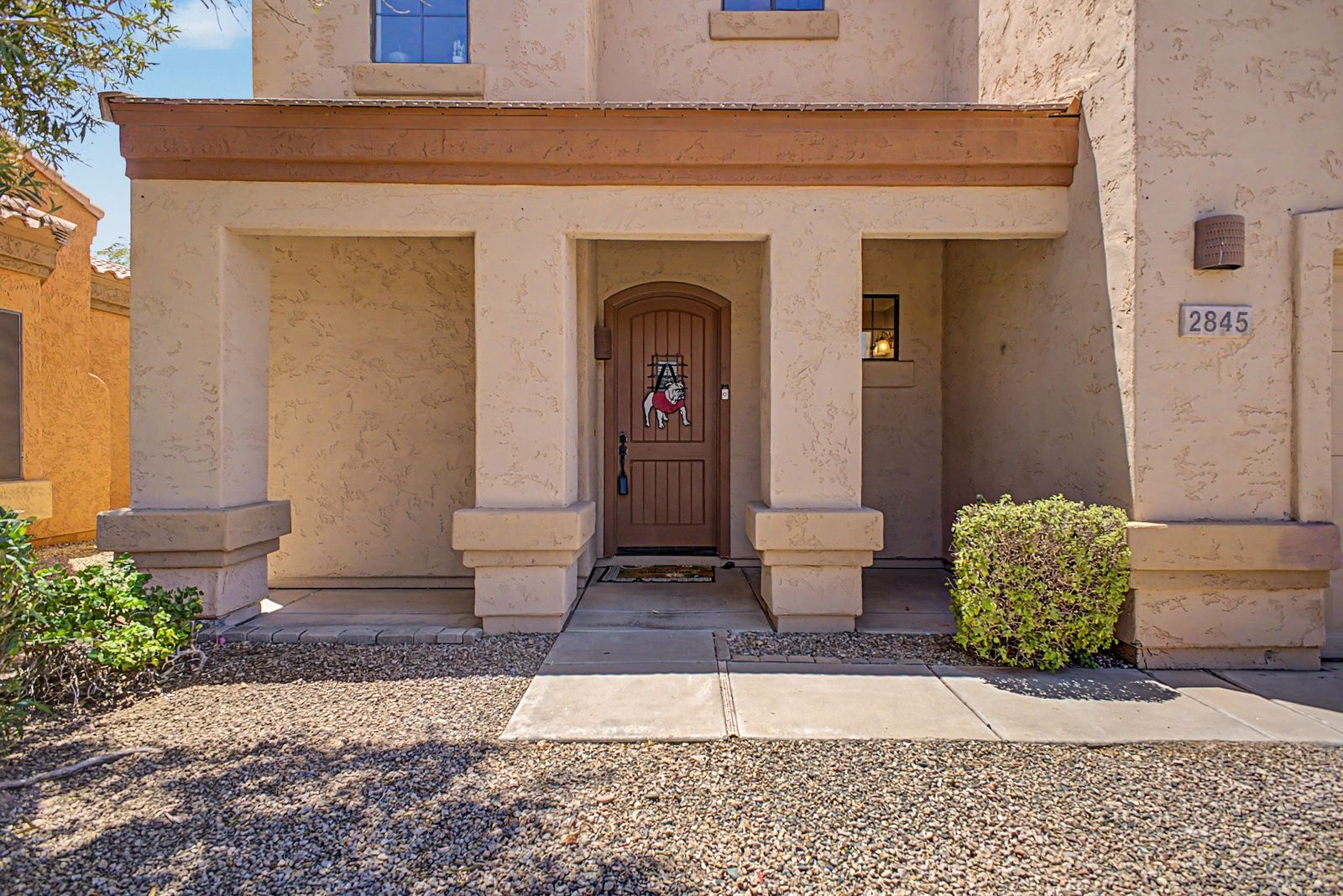 Covered front entry with arched wood door