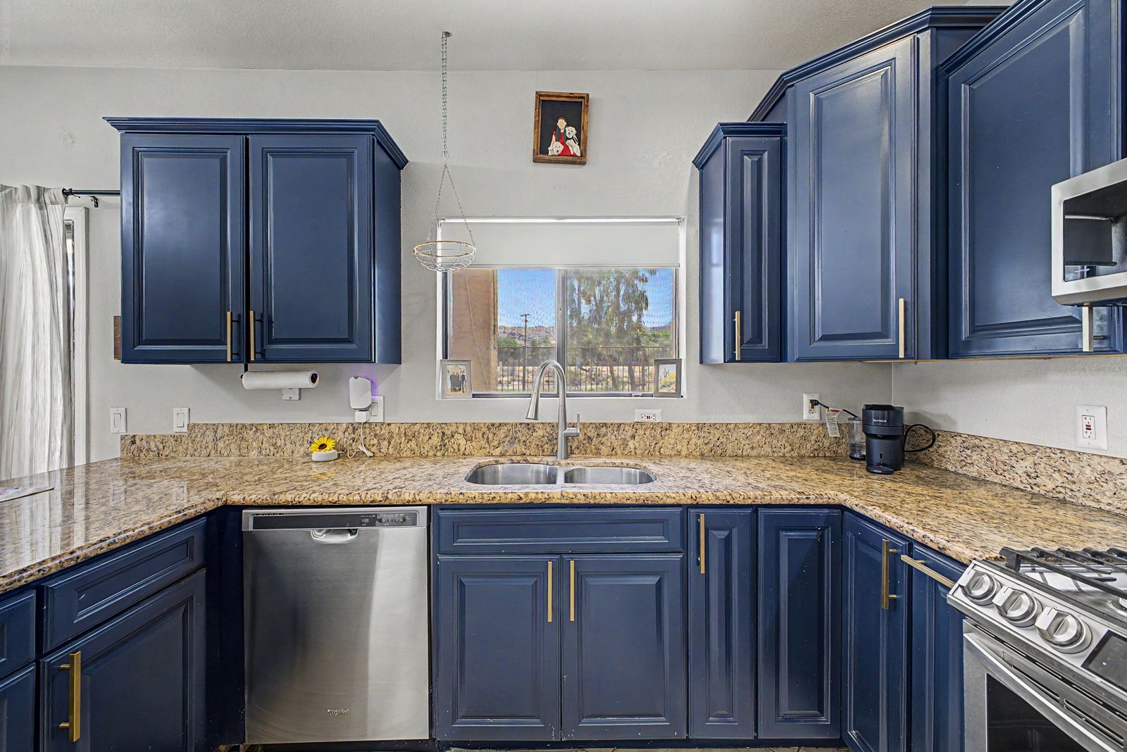 Kitchen sink under a window, with dishwasher
