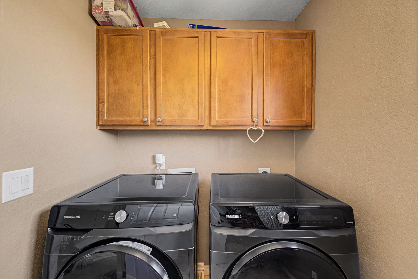 Laundry room with washer, dryer and upper cabinets