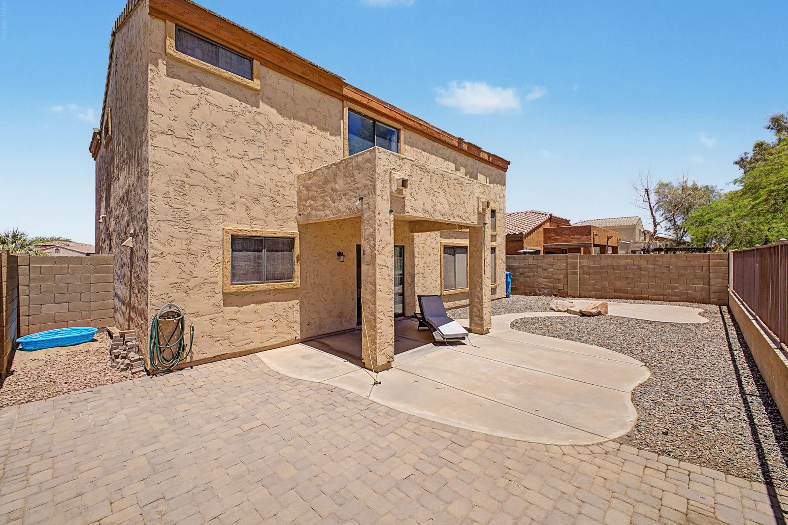 Backyard with covered patio and paver walkway